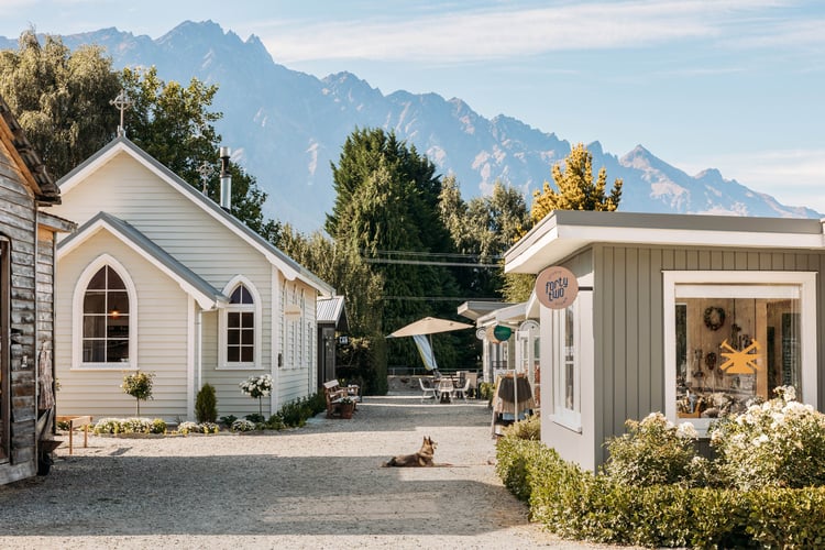 Little shops on a sunny day in front of mountains.