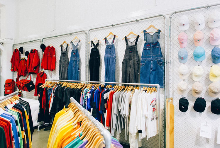 Denim overalls and hats on a wall at Emporium Vintage Boutique Wellington.