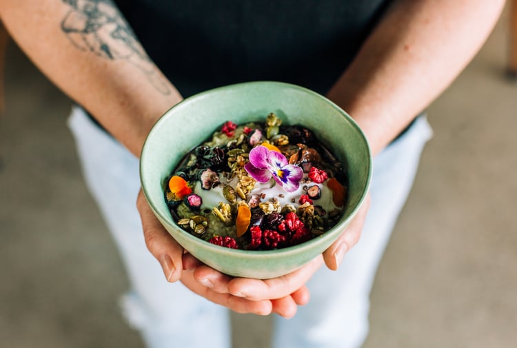 Person holding healthy bowl of muesli from Frank, Hamilton.