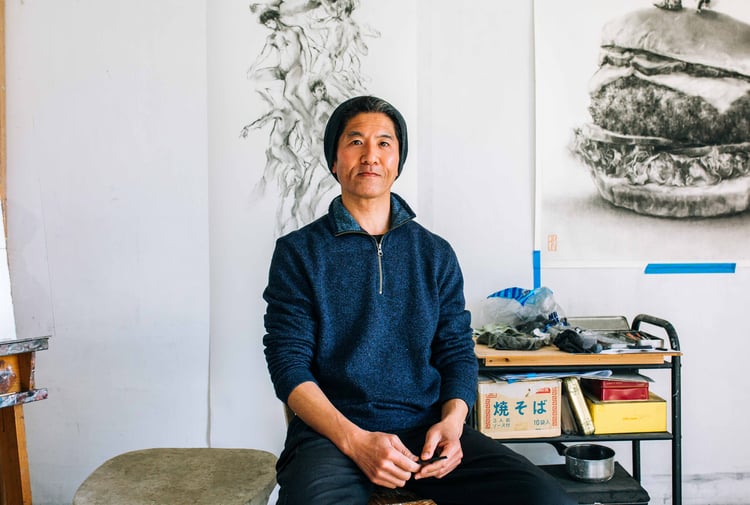 Naga Tsutsumi sitting on a chair.