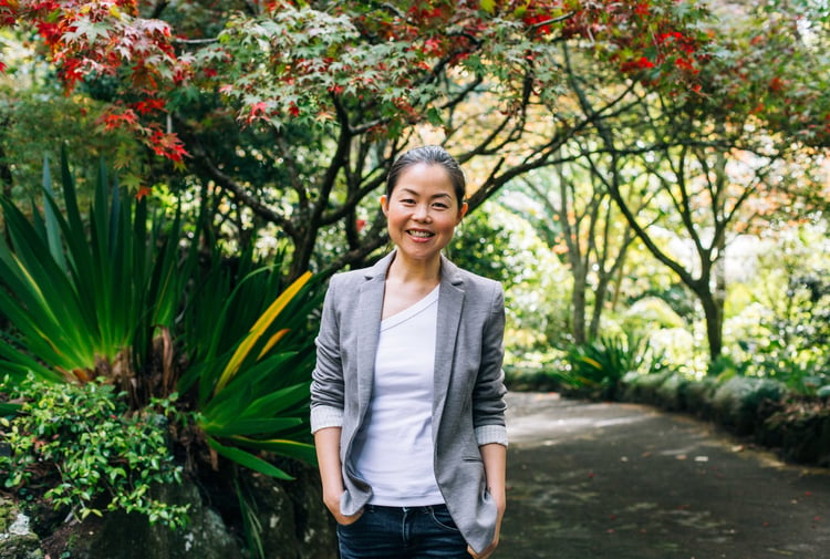 Lisa smiling to camera amongst some beautiful trees.