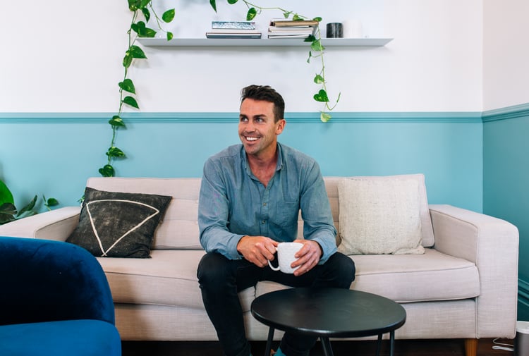 A photo of Matt Stark sitting on a couch.