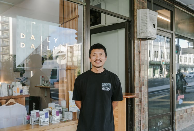 Albert outside his cafe smiling to camera.