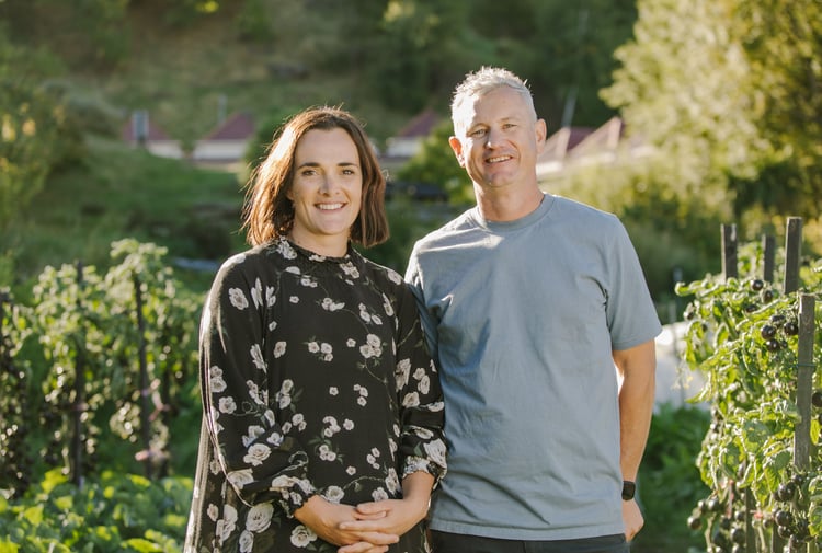 Hayley and Chris smiling at the camera from their garden.