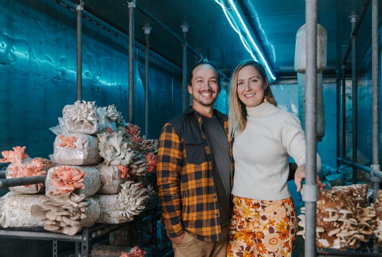 Kimi and Zane standing next to their fungi smiling to camera.