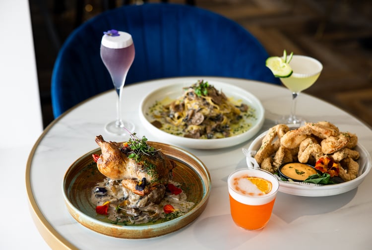 Plates of food and cocktails on a table.