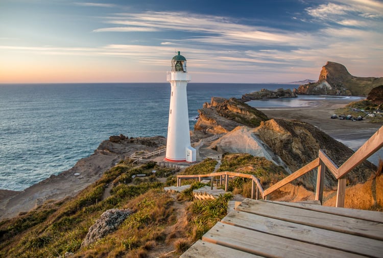A view of a white light house at dusk at Castlepoint in New Zealand.