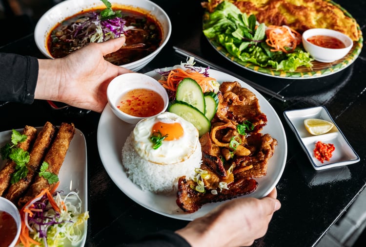 Food dishes being placed on the table at Saigon 60's.
