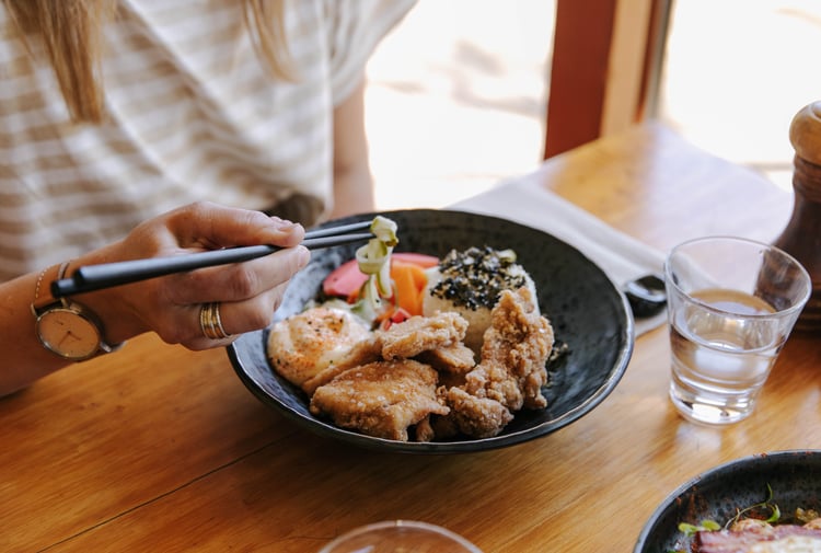 A customer is eating a dish at Sime's Kitchen.