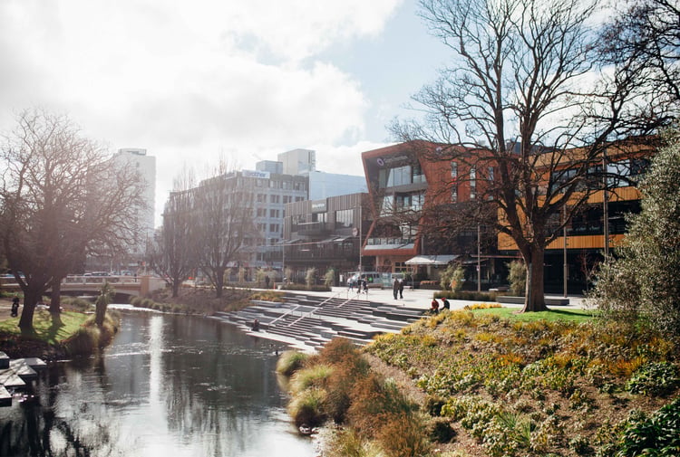 Buildings lined up alongside a river on a sunny day.