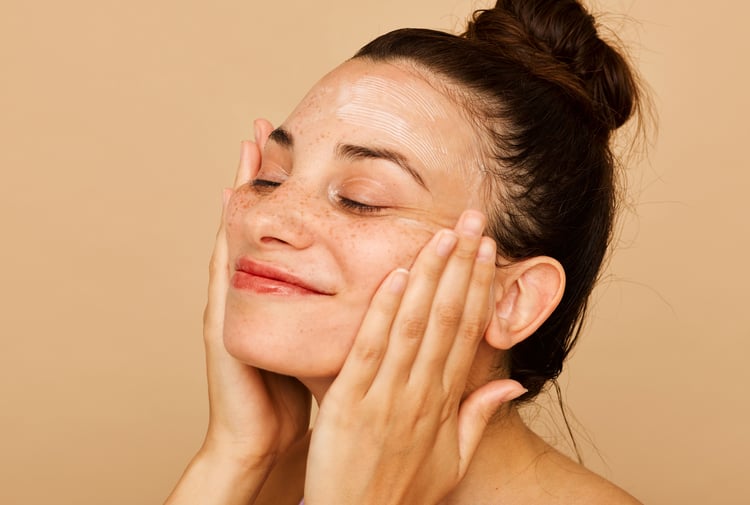 A woman pushing hands onto their face.