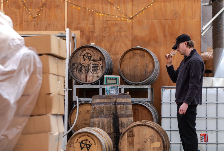A distiller tasting and sampling a spirit in the workshop at The Spirits Workshop.