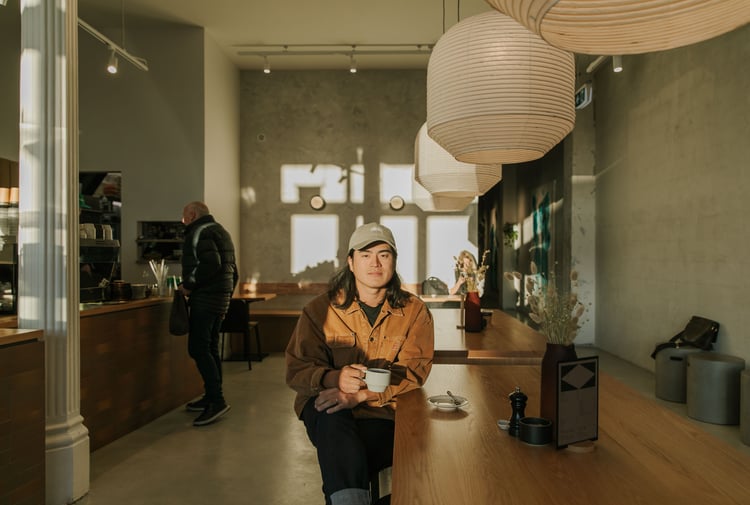Christchurch cafe owner Sung Park drinking a coffee in the sun-drenched space of Akin