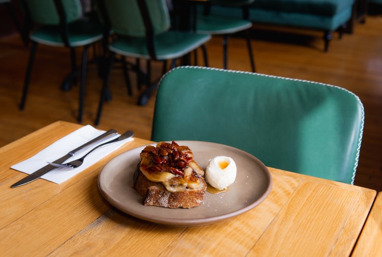 Elevated version of french toast with grilled bananas and a quenelle of cream on the side
