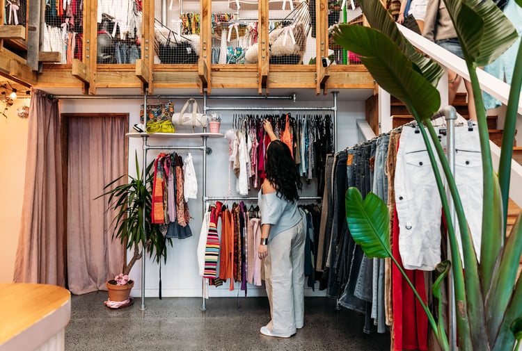 Customer browsing clothing racks in a vintage store.