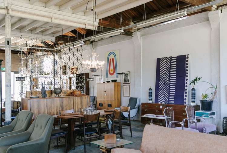 Chairs, lamps and artwork on display in a vintage store.