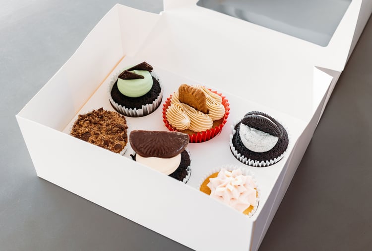 Colourful cupcakes in a white box.