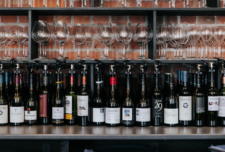 Bottles of red wine lined up in a row on a table.