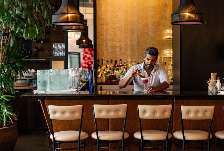 A man making a cocktail at a bar.