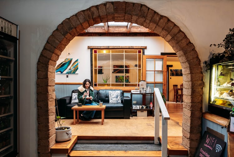 A woman sitting on a couch in a cafe.