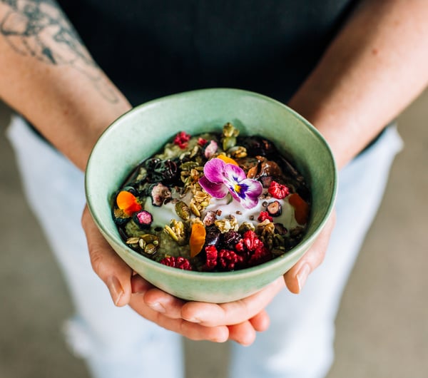 Person holding healthy bowl of muesli from Frank, Hamilton.