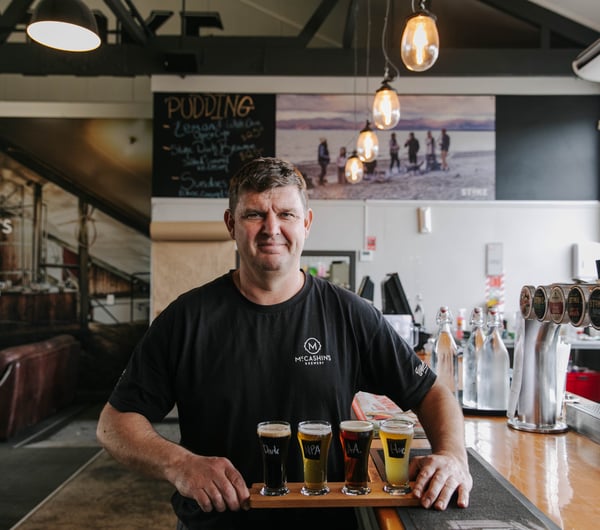 Man holding beer flight from McCashin's.