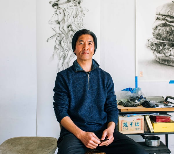 Naga Tsutsumi sitting on a chair.
