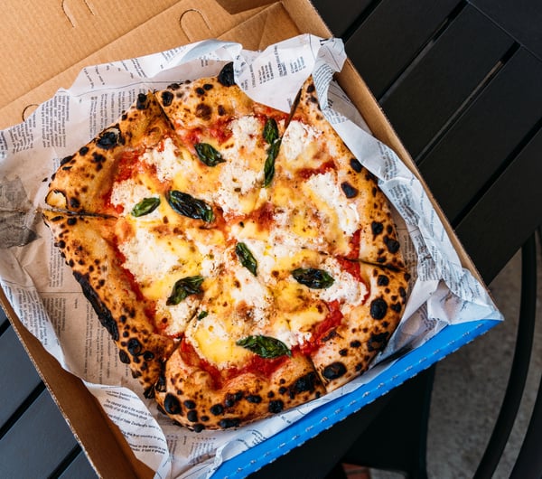 A close up of a delicious looking pizza in a blue box.