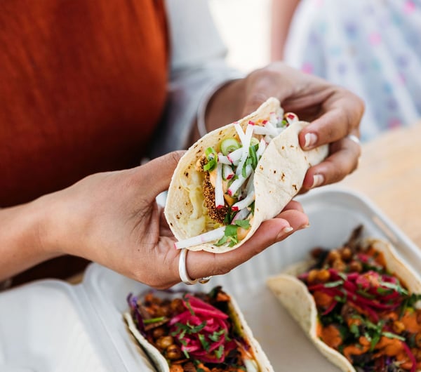 Close up of a person's hands holding a taco.