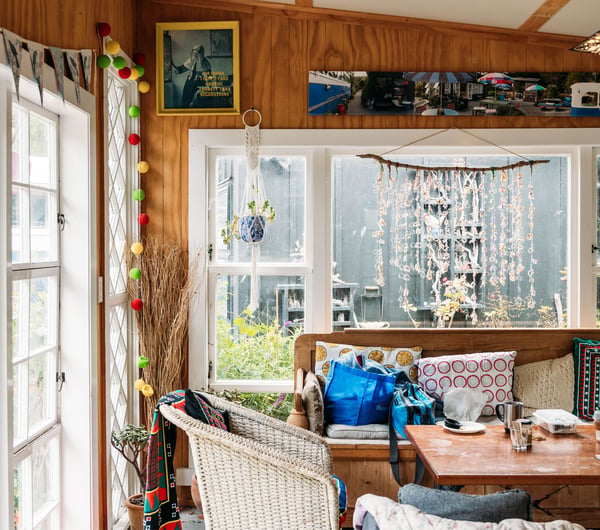 A vintage living room sitting next to large windows.
