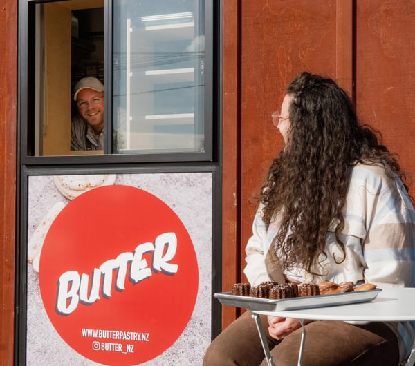 A man smiling from a small window.