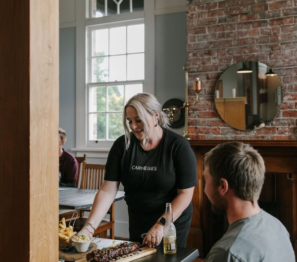 Waitress serving a table at Carnegie's Restaurant and Bar, Fairlie.