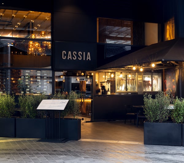 The black entrance to Cassia restaurant on a rainy day.