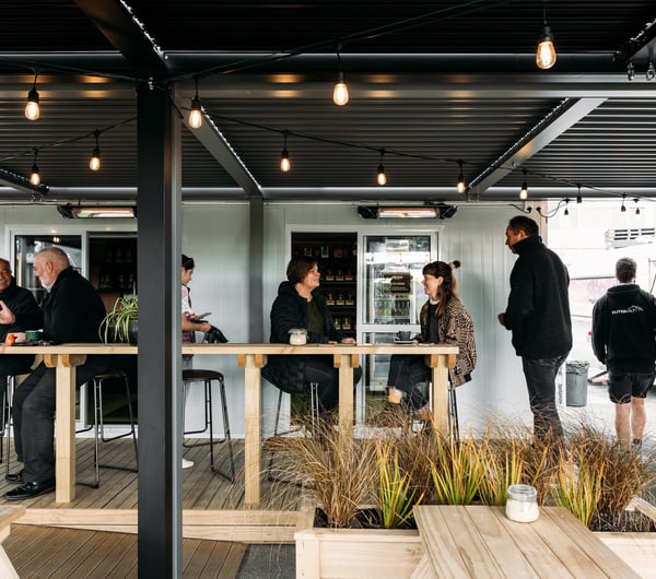 Customers chatting at tables outside the cafe.