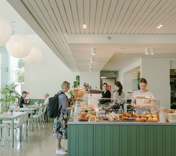 A customer ordering at the white and green counter at Doubles cafe Christchurch.