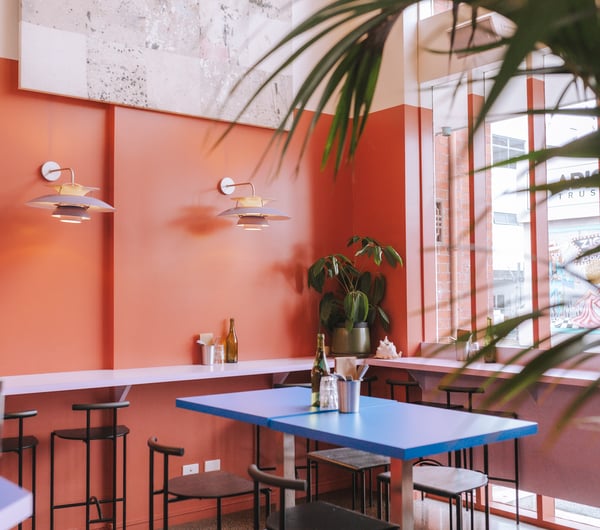A blue high table with bench seats inside the restaurant.