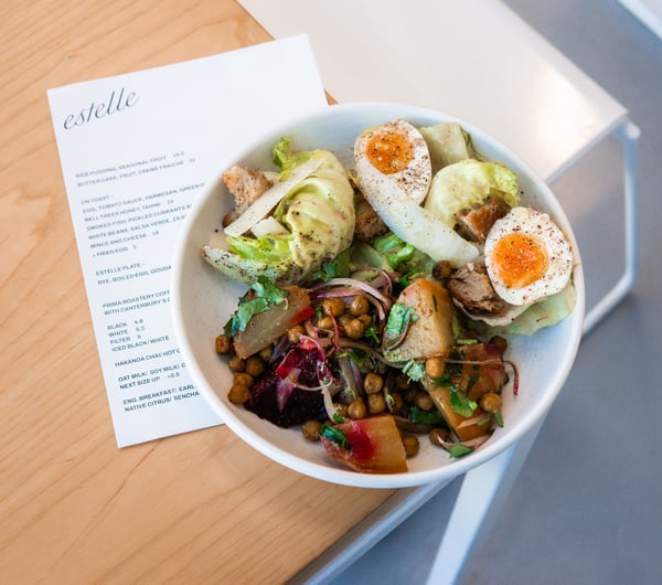A plate of salads and boiled egg in a bowl on a table.