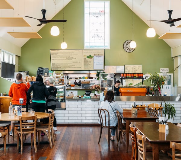 A large cafe space with a green painted wall.
