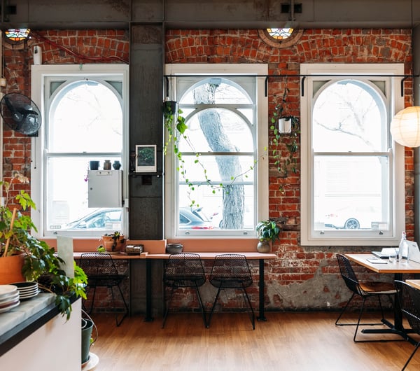 A cafe with a brick wall and large ceilings.