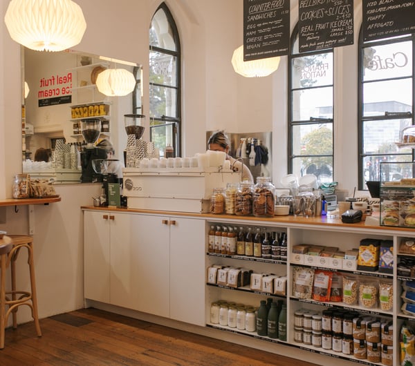 Cafe counter and shelves lined with pantry goods inside Frances Nation Café.