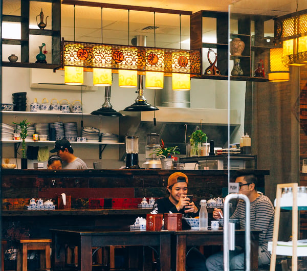 Two customers at a table in Garden Place Noodle Bar, Hamilton.