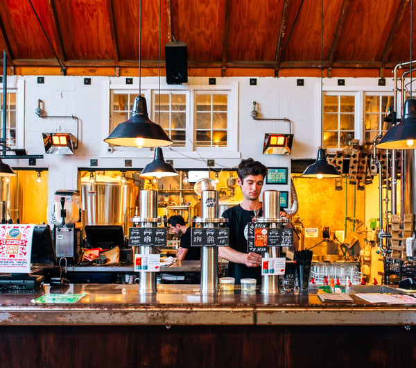 Bartender behind the bar at Good George Dining Hall, Hamilton.