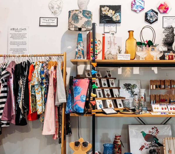 Rack of handmade clothing and vintage decor on shelf at Goody Goodness in Petone