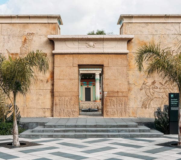 The tall sandstone-coloured walls at the entrance to the Ancient Egyptian Garden.