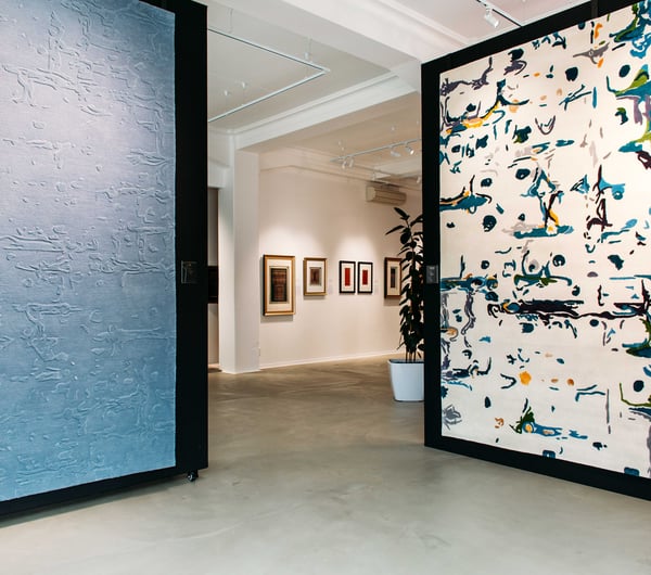 Two giant rugs on display like paintings inside Hanrad Bespoke Rugs.