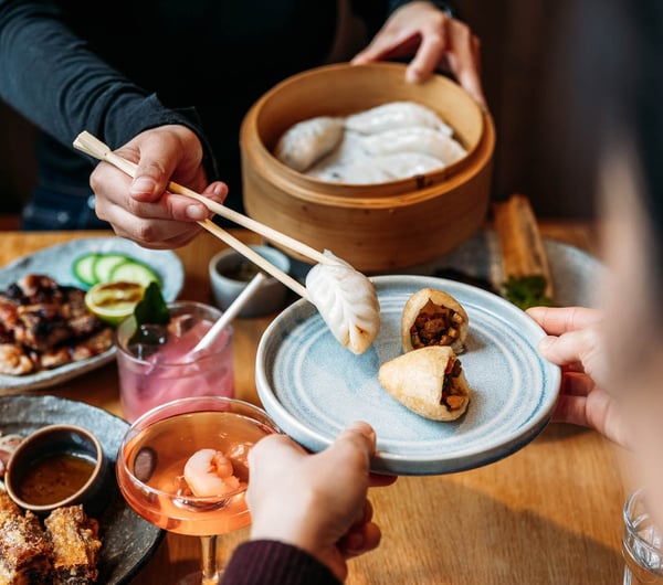 Person serving some dumplings onto plate at Hei Restaurant in Wellington
