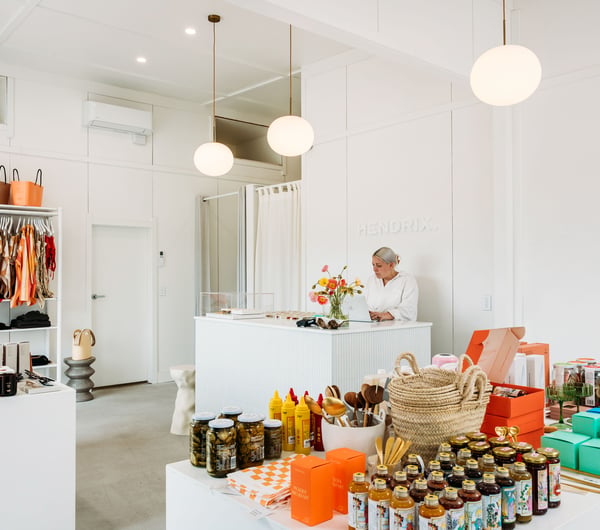 A woman working behind a white counter in a beautifully decorate store.