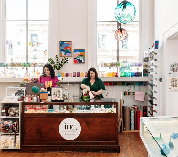 Two women standing behind the counter at Inc. Design Store in Ōamaru