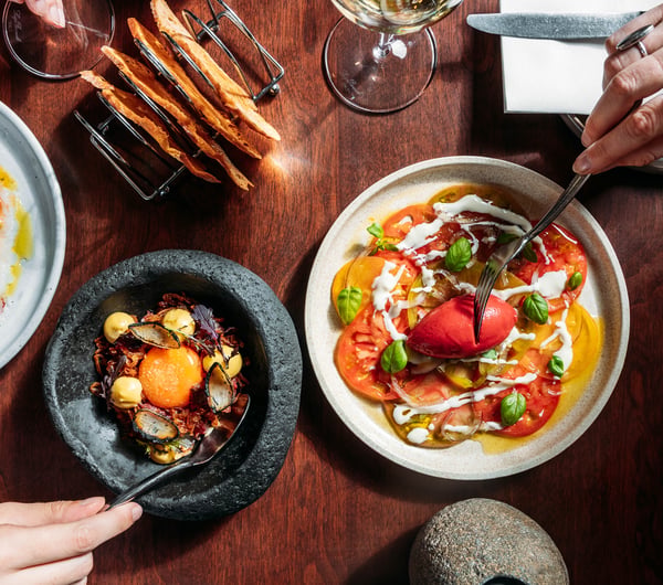 Birdseye view of three elegantly presented dishes on a tabletop.