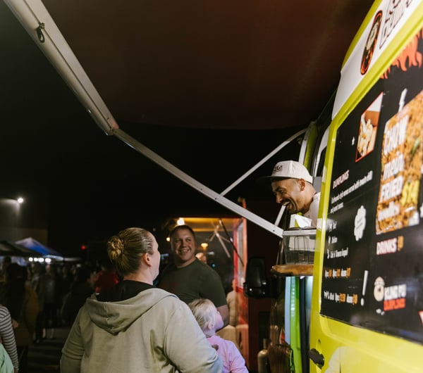Alok laughing with customers at his food truck.